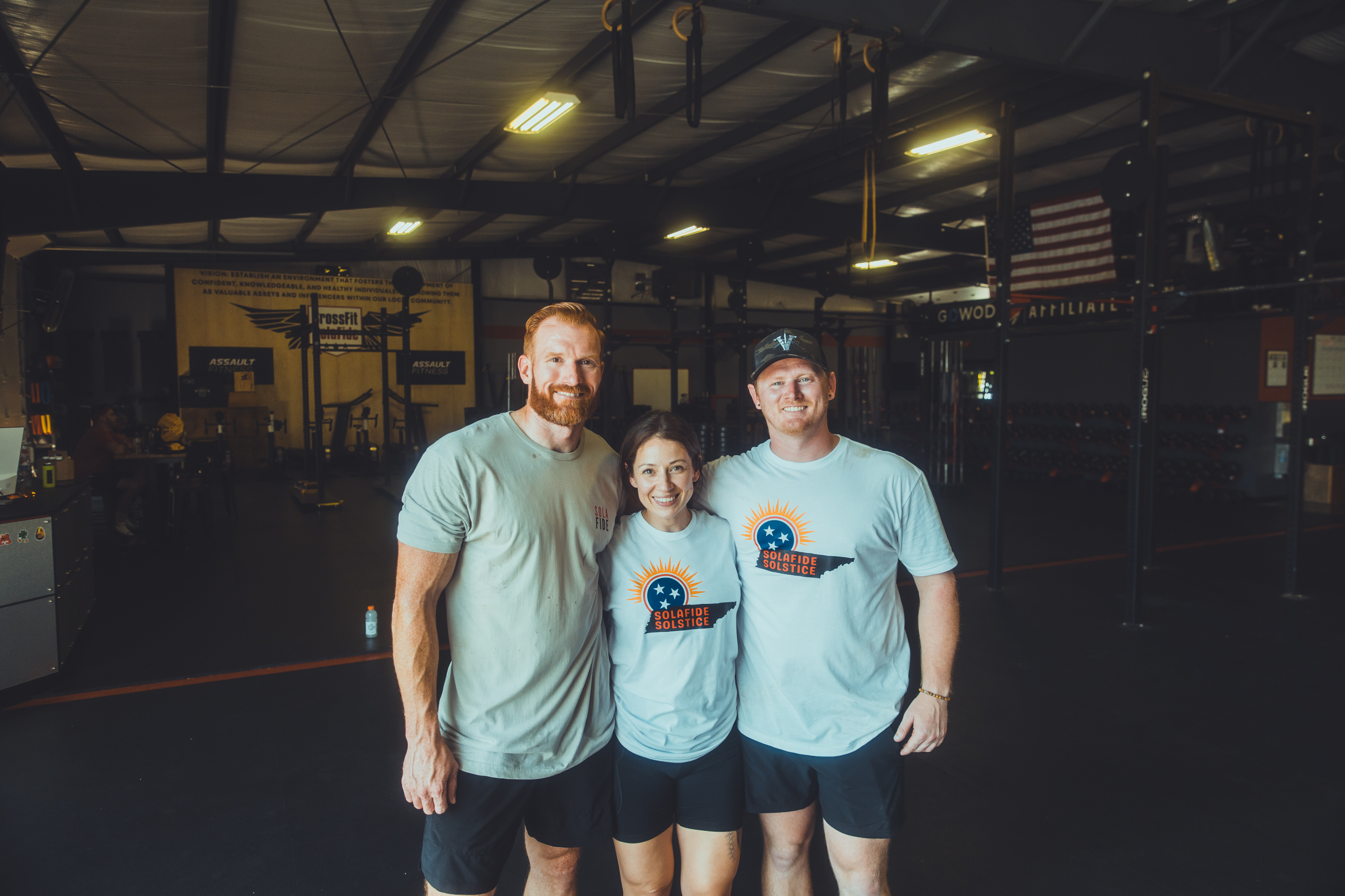 Three members of the CrossFit SolaFide community inside the gym